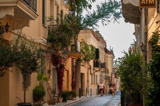 Scenic pedestrian street in Plaka lined with neoclassical buildings, cafés, and greenery, located just a short stroll from Hellenic Vibes Smart Hotel in the heart of Athens. Hellenic Vibes Smart hotel, hotel near Syntagma, hotel near Plaka, hotel near Monastiraki, hotel near Acropolis, smart hotel in Athens, luxury suites Athens, central Athens accommodation, Athens city center attractions, Plaka neighborhood Athens, shopping streets near hotel