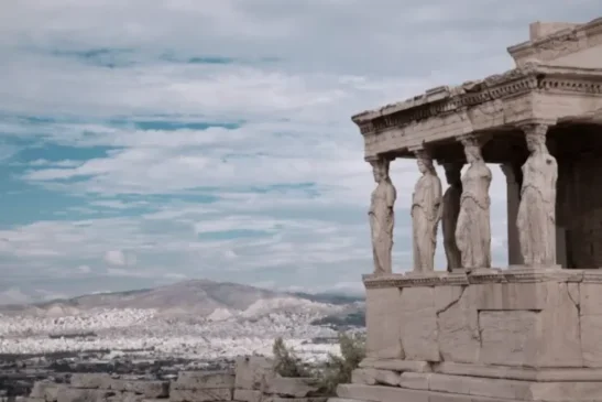 ); View of the Erechtheion and its Caryatid Porch on the Acropolis, located just moments from Hellenic Vibes Smart hotel, overlooking the city of Athens under a bright sky Hellenic Vibes Smart hotel, hotel near Syntagma, hotel near Acropolis, hotel near Monastiraki, central Athens accommodation,